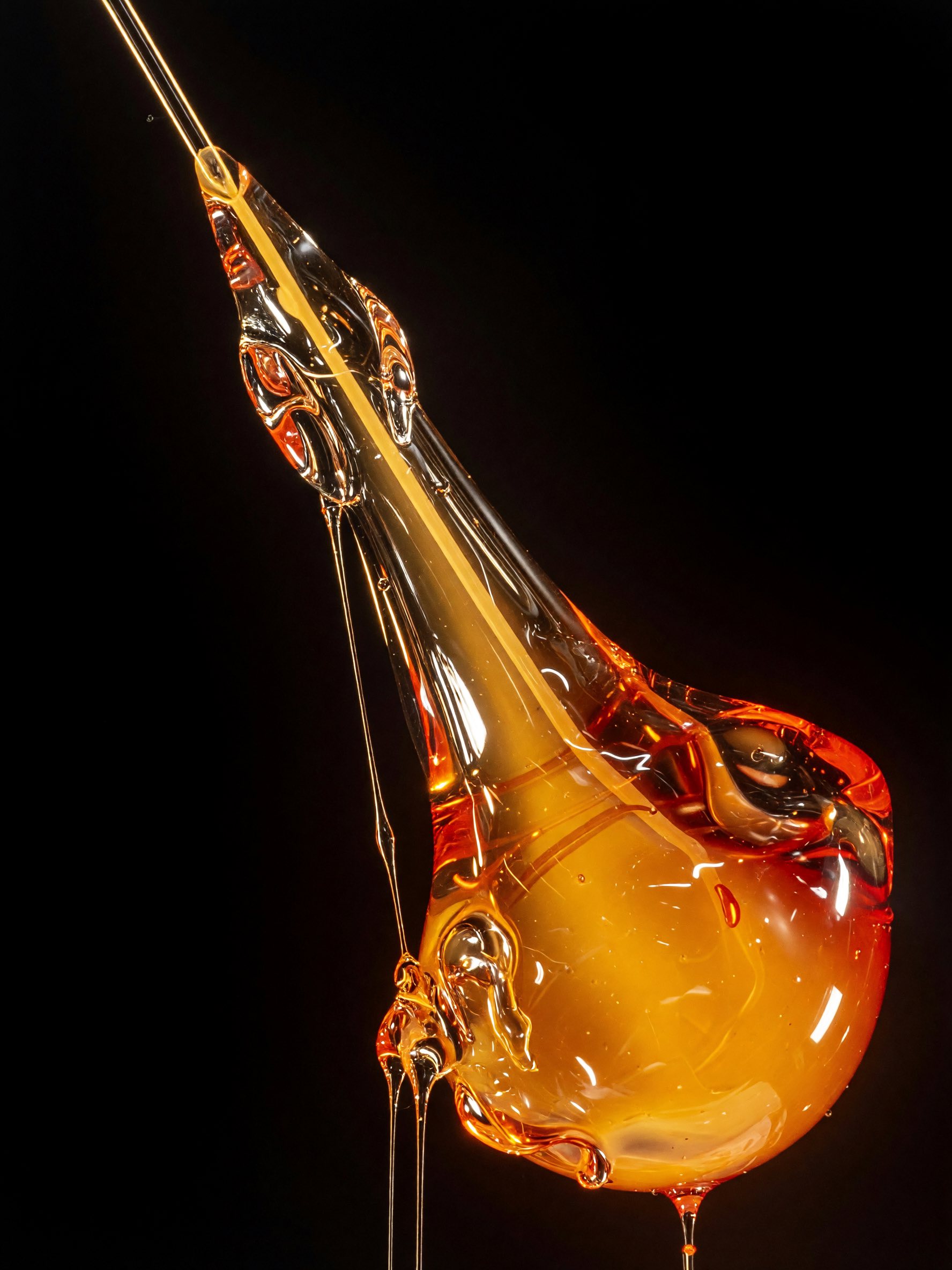 Abstract render: a glossy amber molten glass form