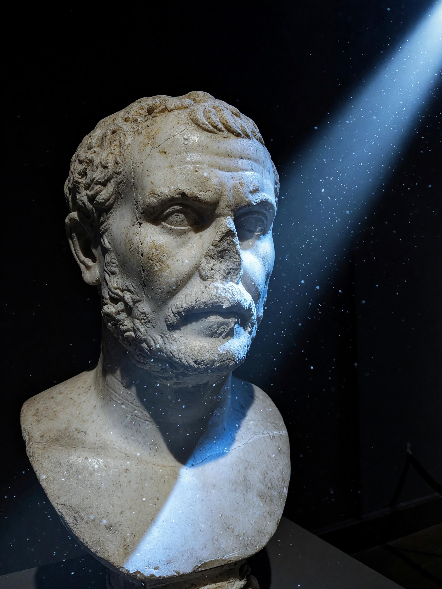 Sculpture render: a weathered marble bust under a cool blue light